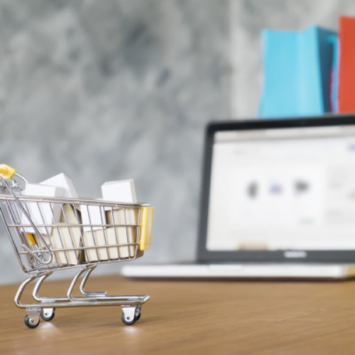 Business theme, internet online shopping concept, shopping delivery, shopping cart carry shopping mail box and blur background of shopping bag and open laptop