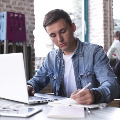 teenage-student-sitting-table-with-notebook-writing_23-2148166384